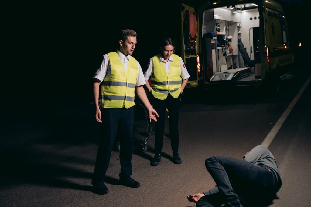 Paramedics Looking at the Person Lying on the Street